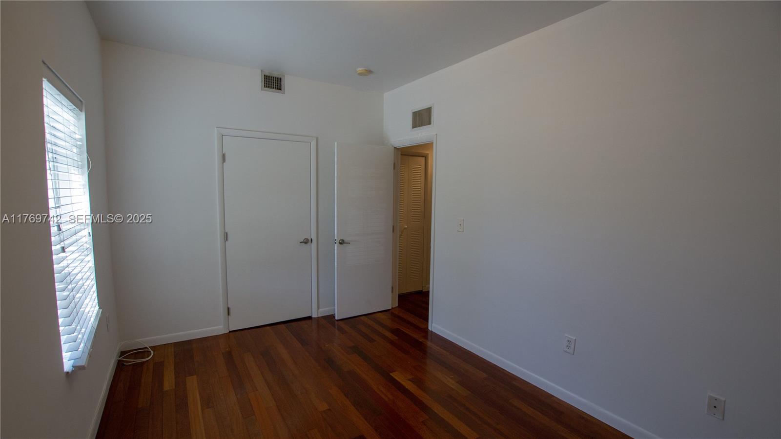 577 Northeast 62nd Street, Unit 2 Miami, FL 33138 - Photo 6 of 21 a view of an empty room with wooden floor and a window