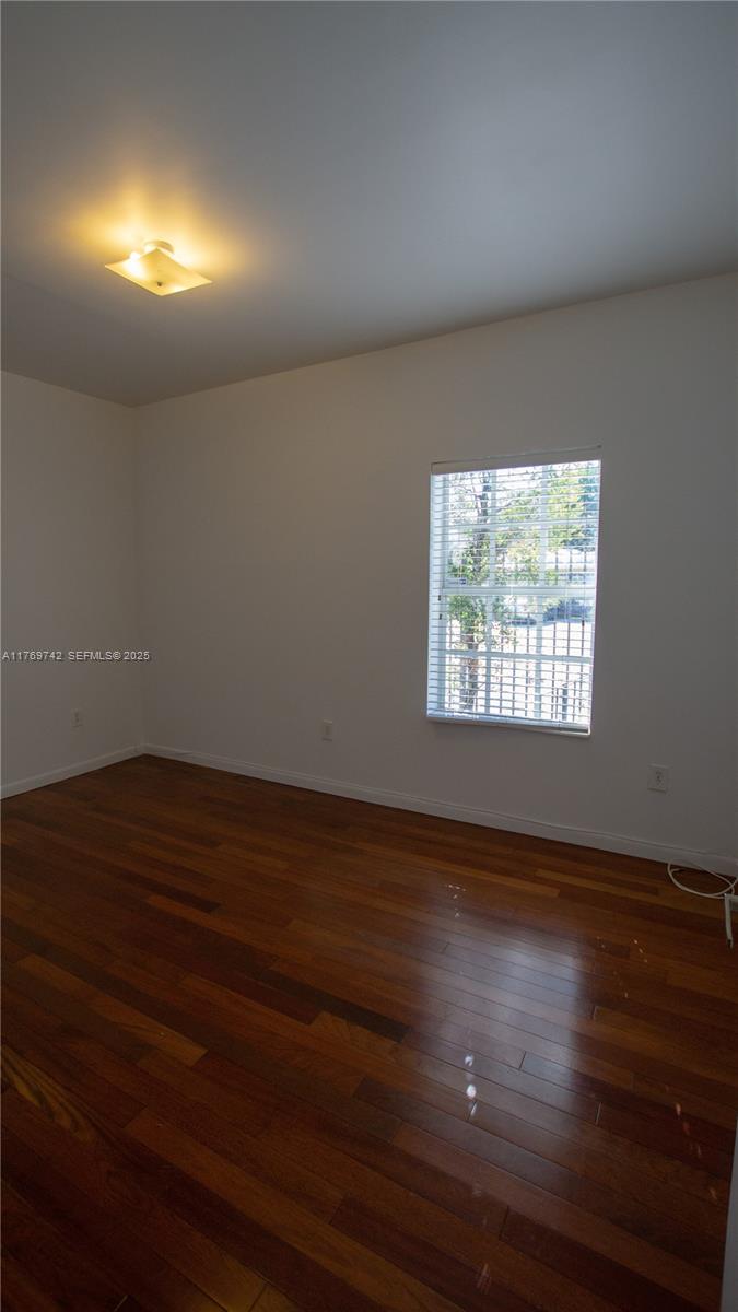 577 Northeast 62nd Street, Unit 2 Miami, FL 33138 - Photo 8 of 21 an empty room with wooden floor and windows