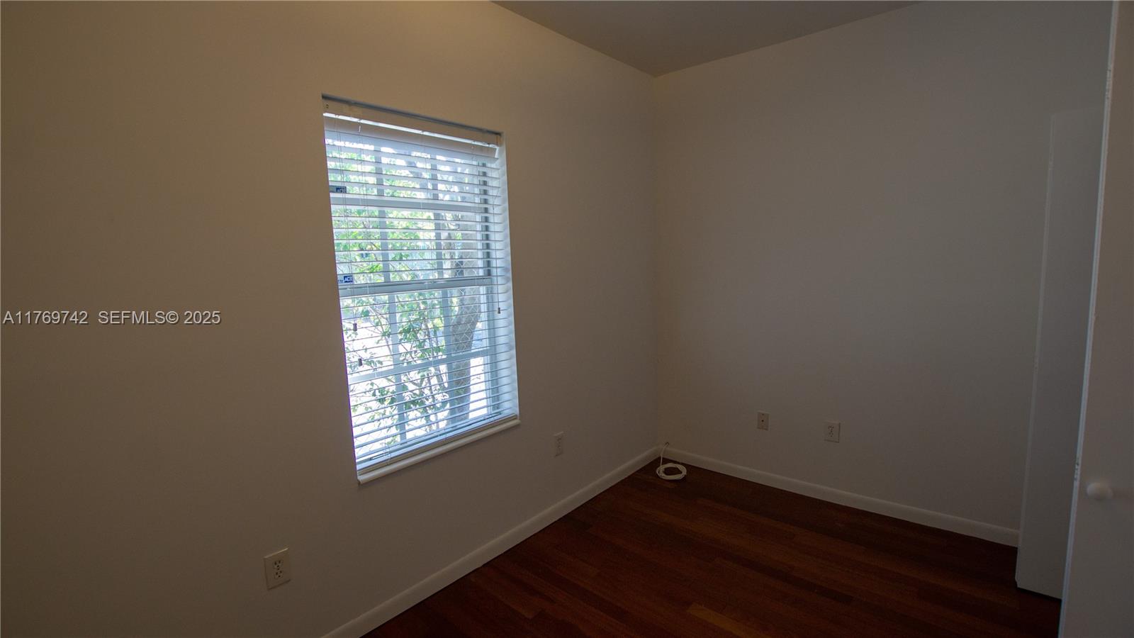 577 Northeast 62nd Street, Unit 2 Miami, FL 33138 - Photo 10 of 21 a view of an empty room with wooden floor and a window
