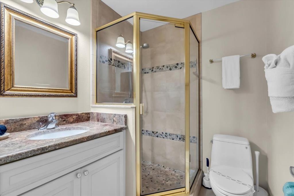 757 Beach Road, Unit 310 Sarasota, FL 34242 - Photo 17 of 31 a bathroom with a granite countertop sink toilet and shower