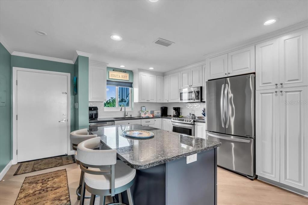 757 Beach Road, Unit 310 Sarasota, FL 34242 - Photo 7 of 31 a kitchen with a refrigerator a stove a sink and a refrigerator