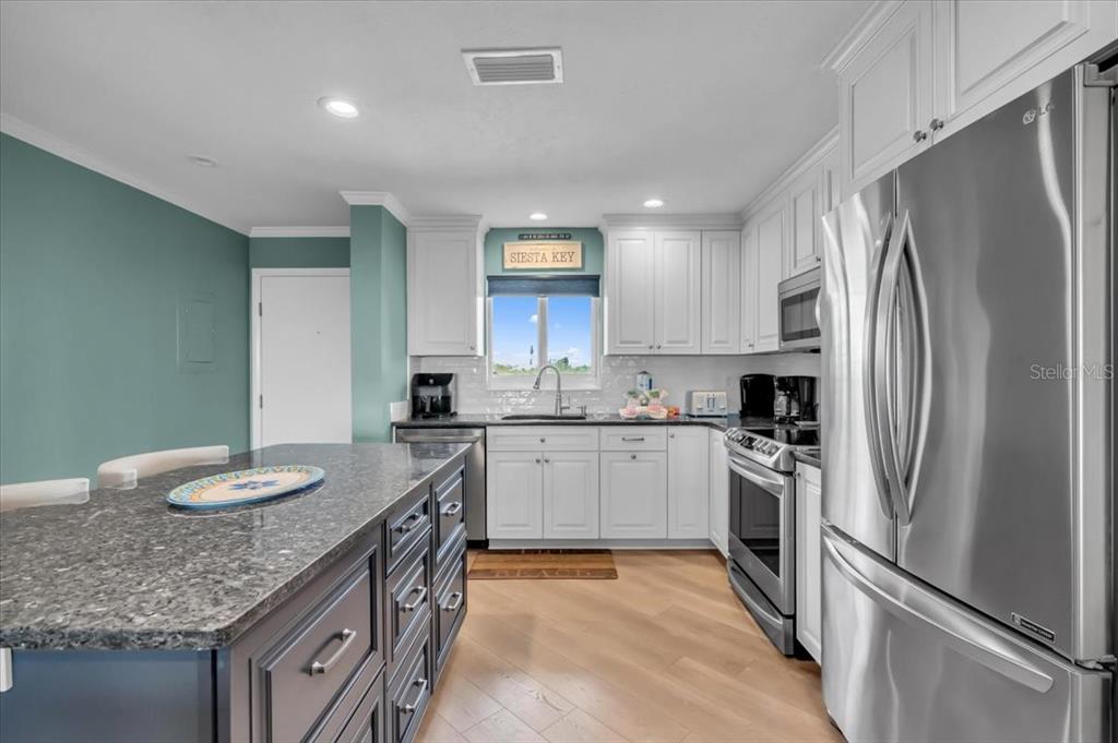 757 Beach Road, Unit 310 Sarasota, FL 34242 - Photo 9 of 31 a kitchen with stainless steel appliances granite countertop a sink stove and refrigerator
