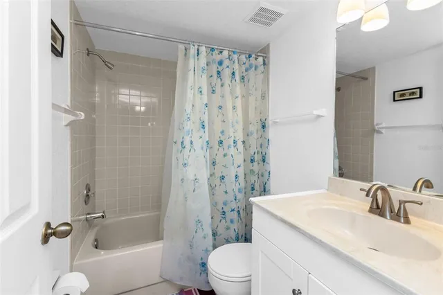 a bathroom with a granite countertop sink a toilet and shower