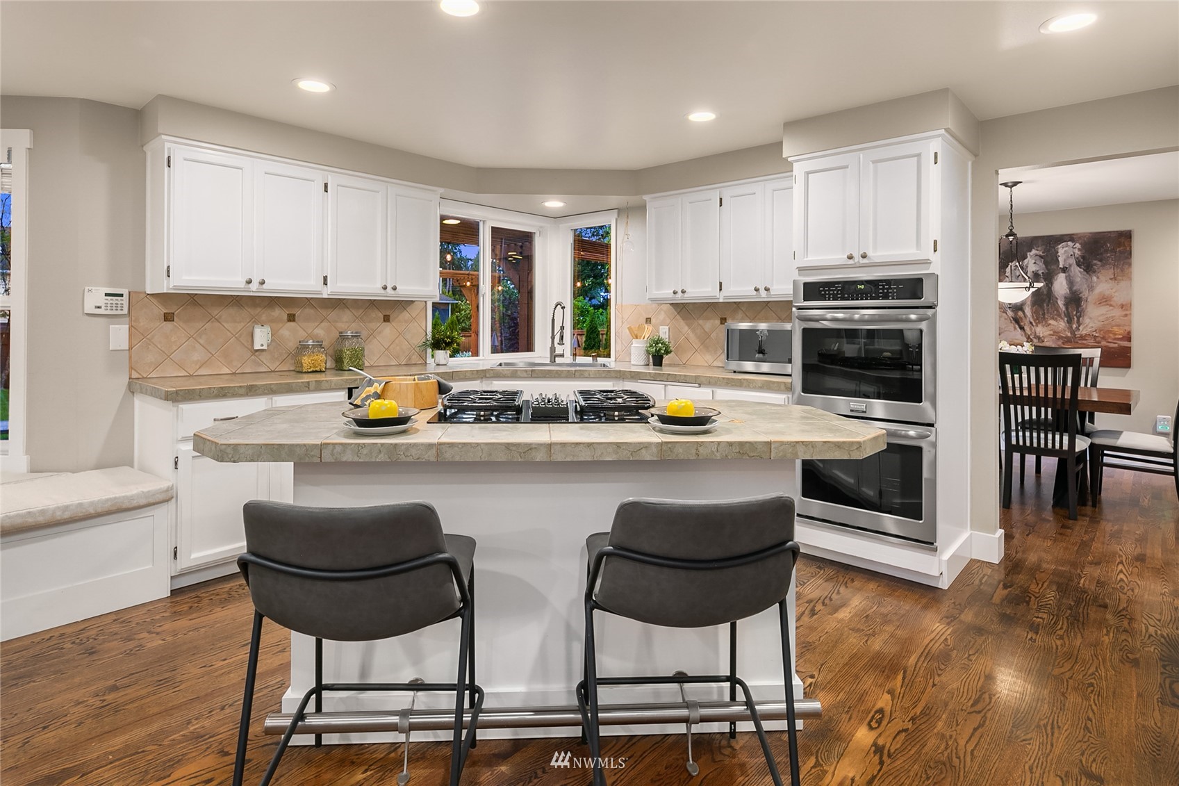 3228 211th Street Southeast Bothell, WA 98021 - Photo 9 of 40 a kitchen with a table chairs microwave and cabinets