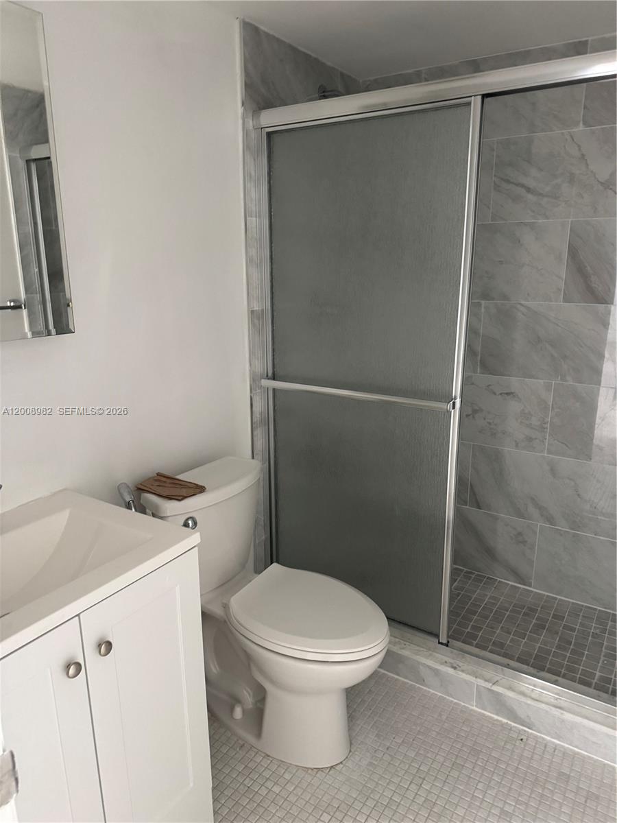 7747 Southwest 86th Street, Unit D105 Miami, FL 33143 - Photo 12 of 14 a white toilet sitting next to a bathroom sink