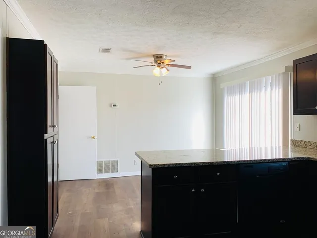 a view of a living room with a ceiling fan and a window