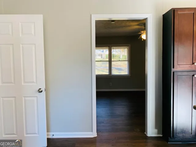 a view of an empty room and wooden floor and a window