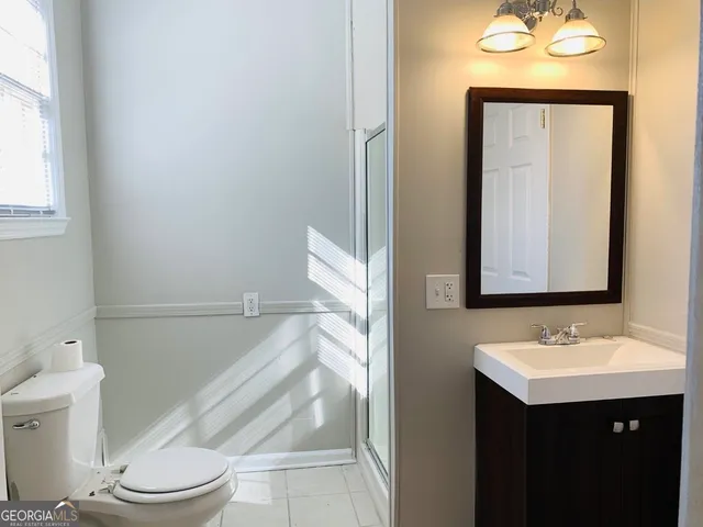 a bathroom with a sink vanity mirror and toilet