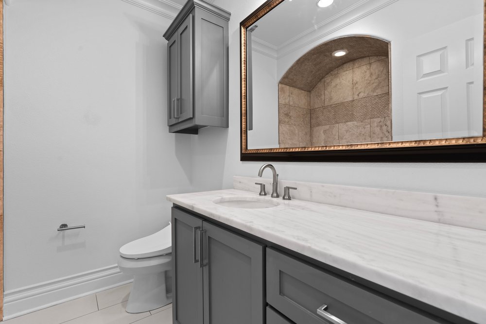 1609 Hartford Road, Unit A Austin, TX 78703 - Photo 33 of 39 Elegant gray cabinetry complements the smooth marble countertop and polished faucet in this well-appointed bathroom.