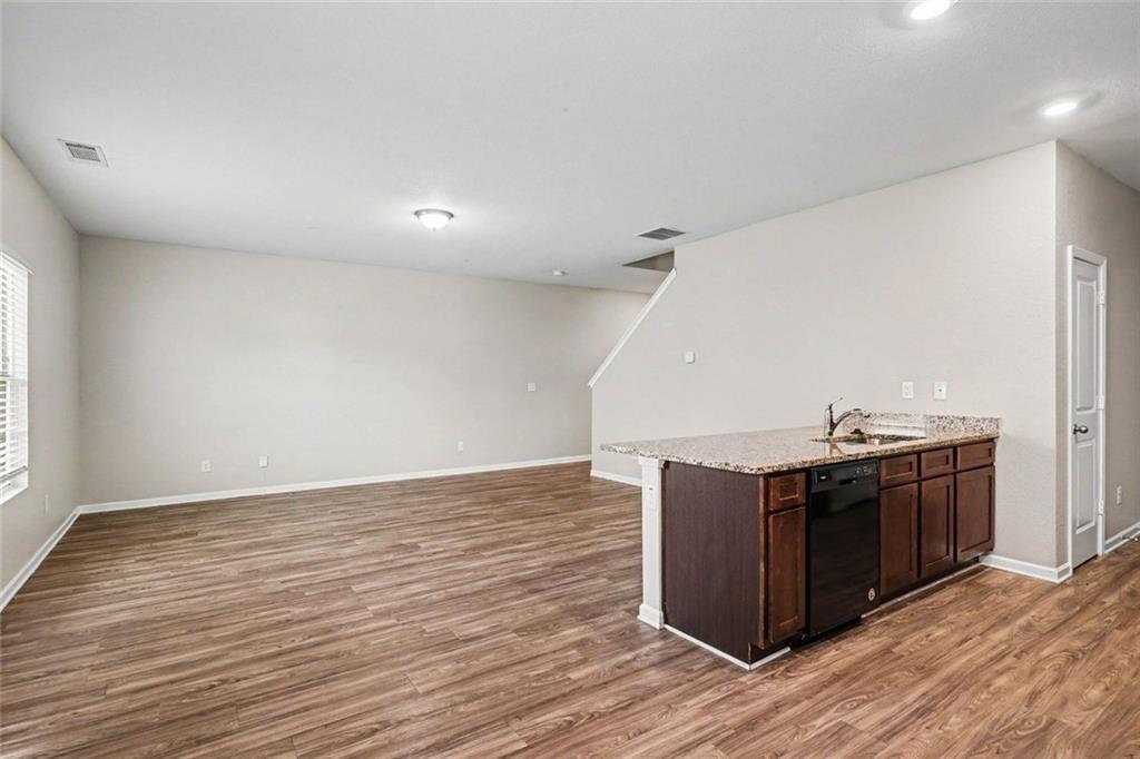 10941 Wheeler Trace Hampton, GA 30228 - Photo 6 of 21 a view of a kitchen with wooden floor and cabinets