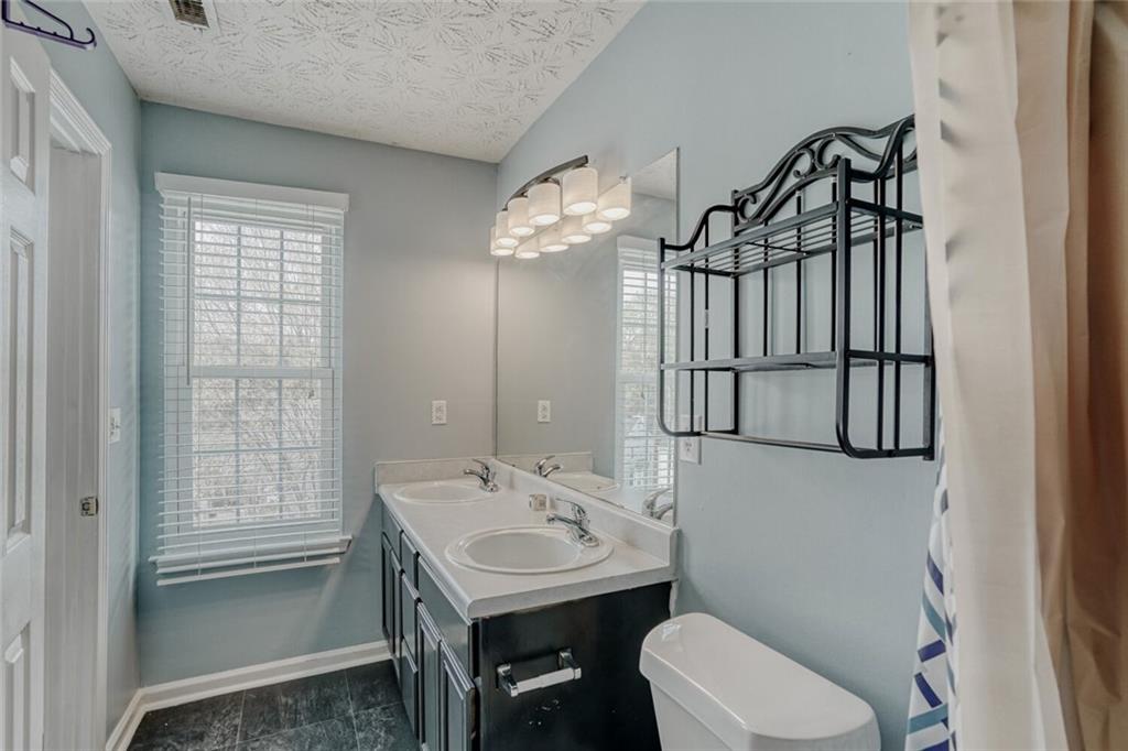 4120 Spring Cove Drive Duluth, GA 30097 - Photo 14 of 24 a bathroom with a sink a toilet and a mirror