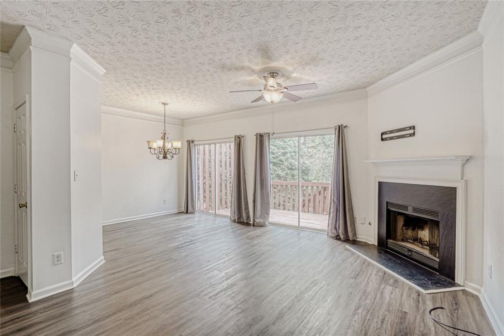 4120 Spring Cove Drive Duluth, GA 30097 - Photo 3 of 24 an empty room with wooden floor fireplace and windows