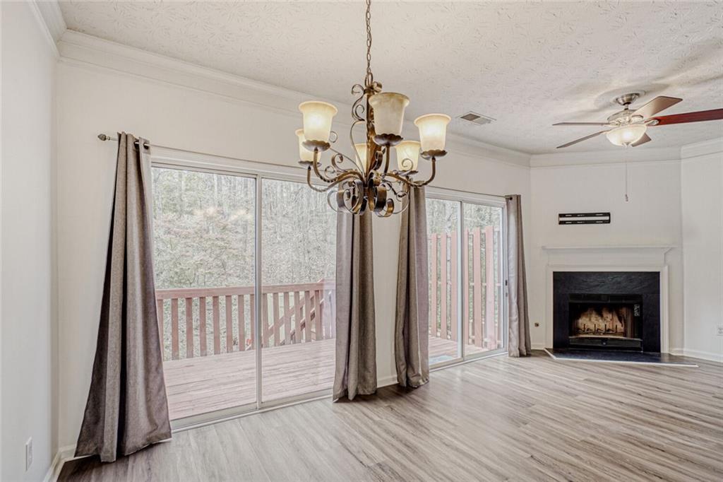 4120 Spring Cove Drive Duluth, GA 30097 - Photo 5 of 24 a view of a livingroom with a fireplace wooden floor and a chandelier