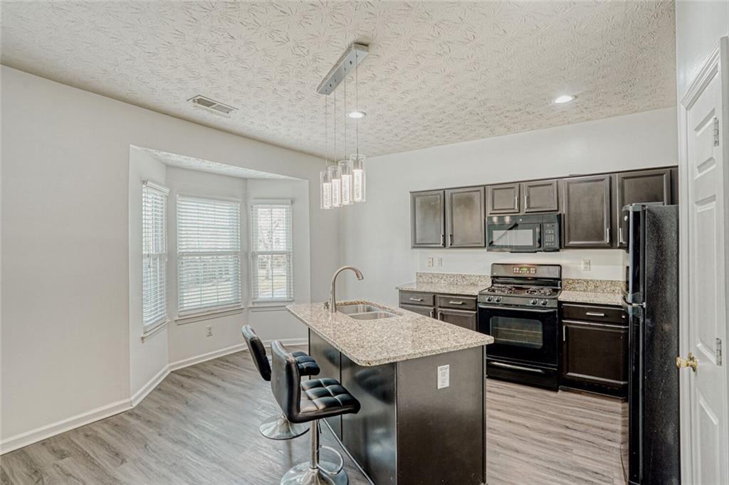 4120 Spring Cove Drive Duluth, GA 30097 - Photo 7 of 24 a kitchen with granite countertop a sink stove and refrigerator