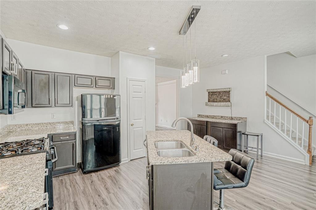 4120 Spring Cove Drive Duluth, GA 30097 - Photo 9 of 24 a kitchen with granite countertop a sink stove and refrigerator