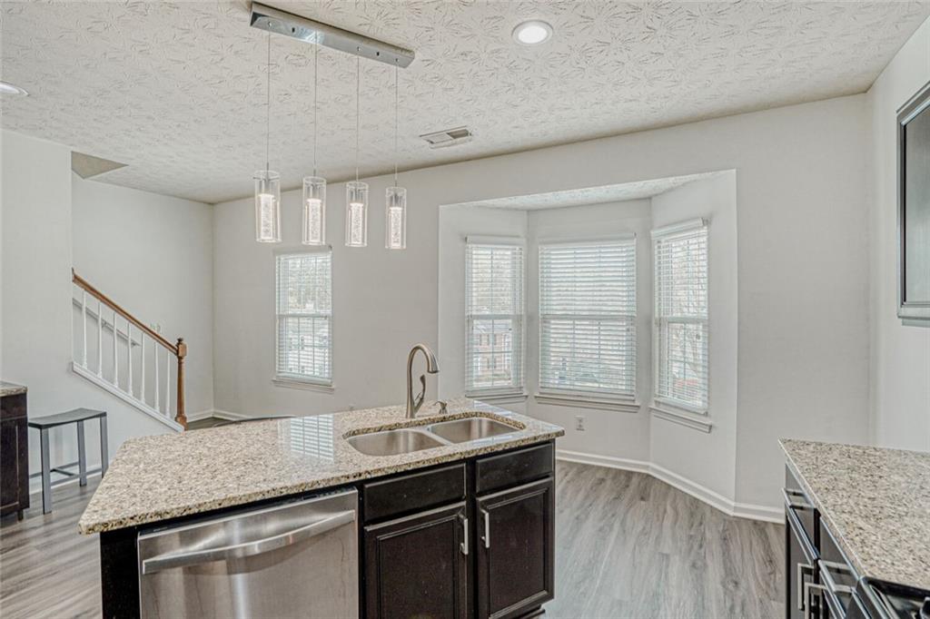 4120 Spring Cove Drive Duluth, GA 30097 - Photo 10 of 24 a kitchen with granite countertop a sink and a stove