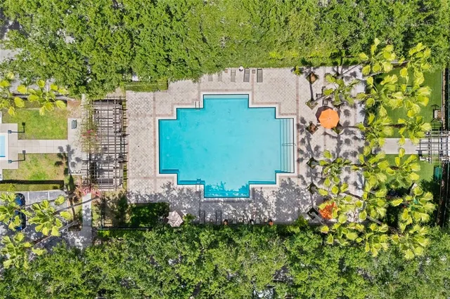 an aerial view of residential house with outdoor space and trees all around