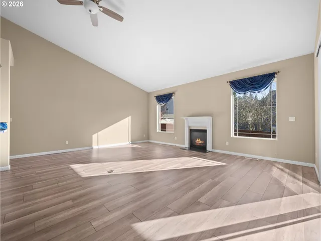 an empty room with windows and fireplace