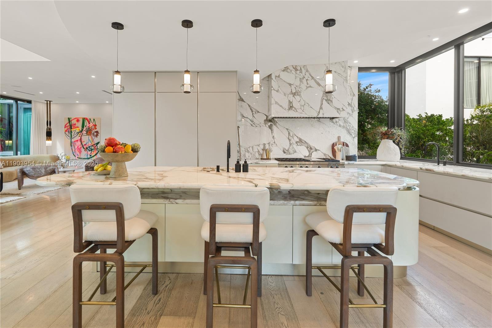 2053 North Bay Road Miami Beach, FL 33140 - Photo 35 of 99 a kitchen with stainless steel appliances kitchen island a table and chairs in it