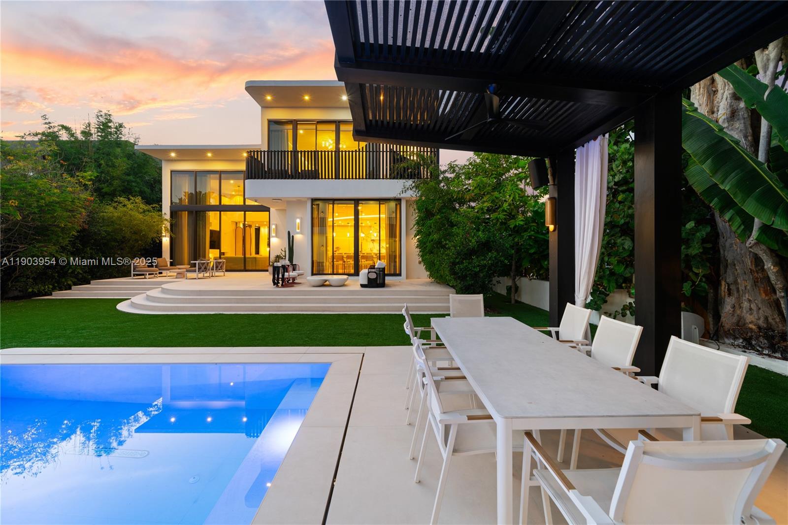 2053 North Bay Road Miami Beach, FL 33140 - Photo 92 of 99 a view of a patio with table and chairs potted plants with wooden floor and fence