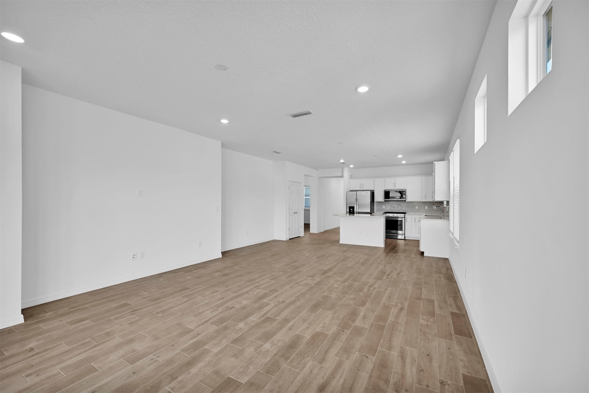 285 Ecliptic Loop Yulee, FL 32097 - Photo 12 of 42 a view of kitchen and empty room with wooden floor