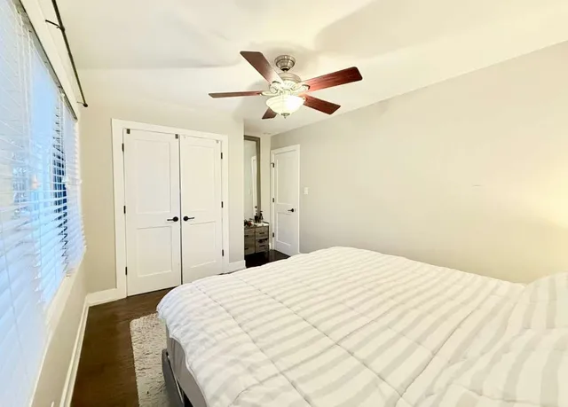 a bedroom with a bed and a ceiling fan