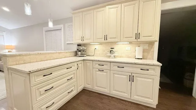 a kitchen with granite countertop white cabinets and white appliances