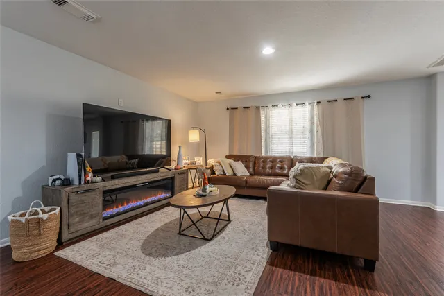 a living room with furniture and a wooden floor