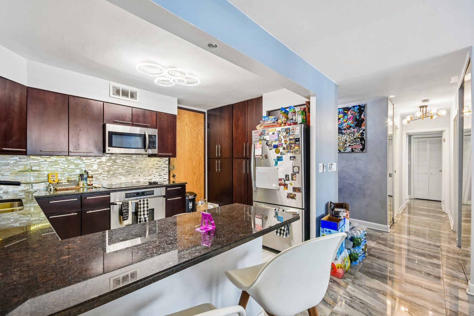 6007 North Sheridan Road, Unit 29F Chicago, IL 60660 - Photo 7 of 19 a kitchen with stainless steel appliances granite countertop a stove refrigerator and cabinets