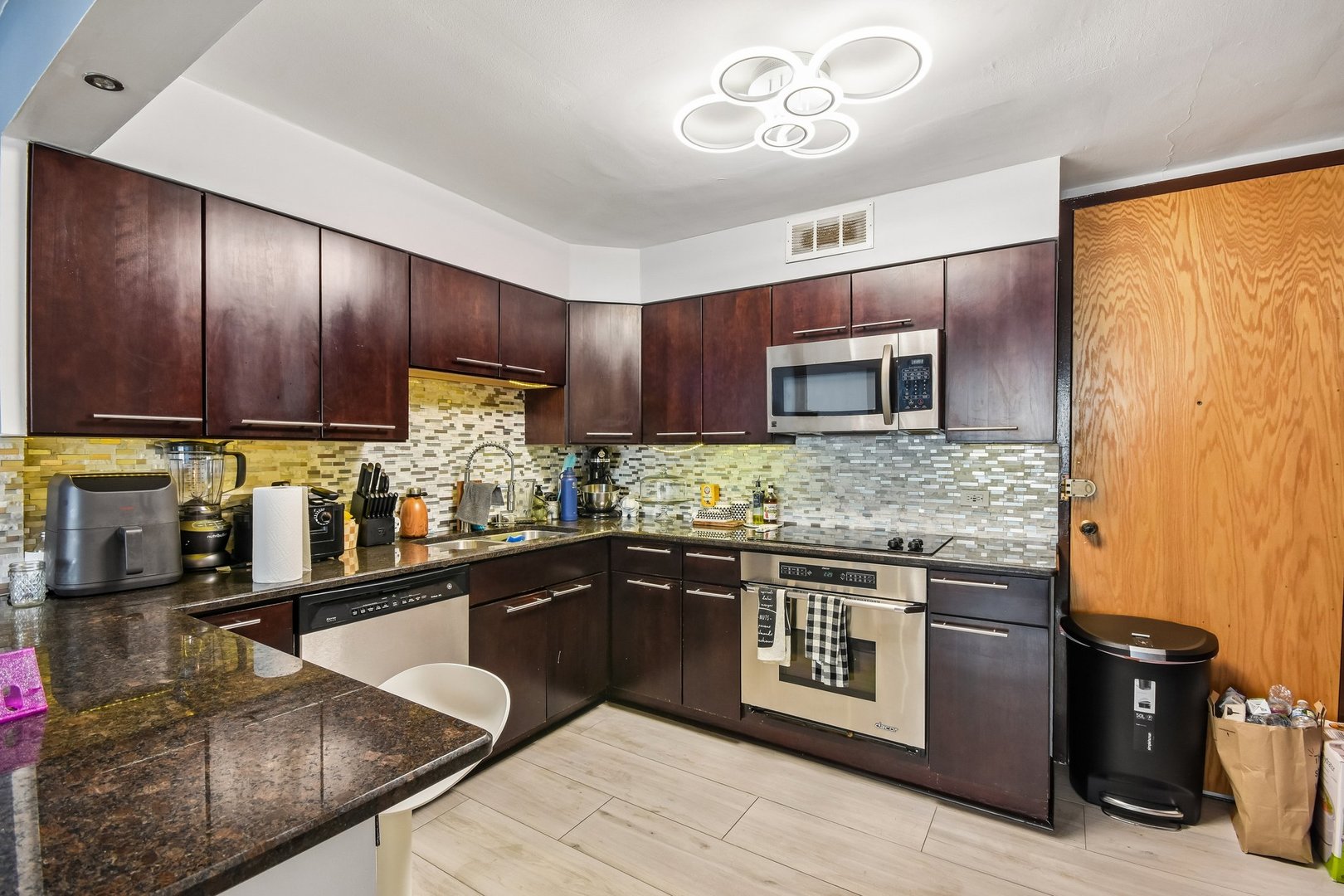 6007 North Sheridan Road, Unit 29F Chicago, IL 60660 - Photo 8 of 19 a kitchen with stainless steel appliances granite countertop a sink stove and microwave