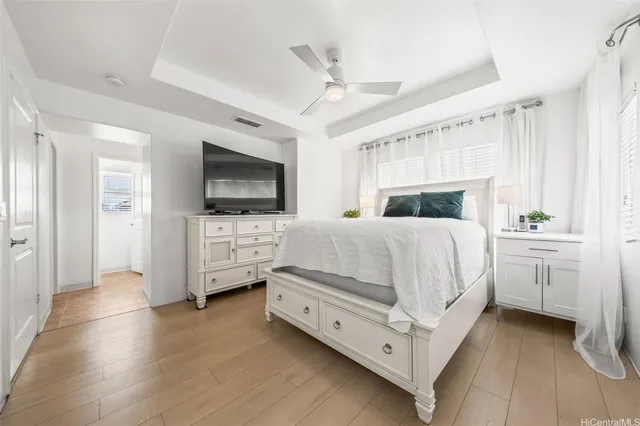 a bedroom with a bed and a flat tv screen on the dresser