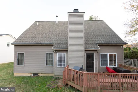 a view of a house with yard and deck