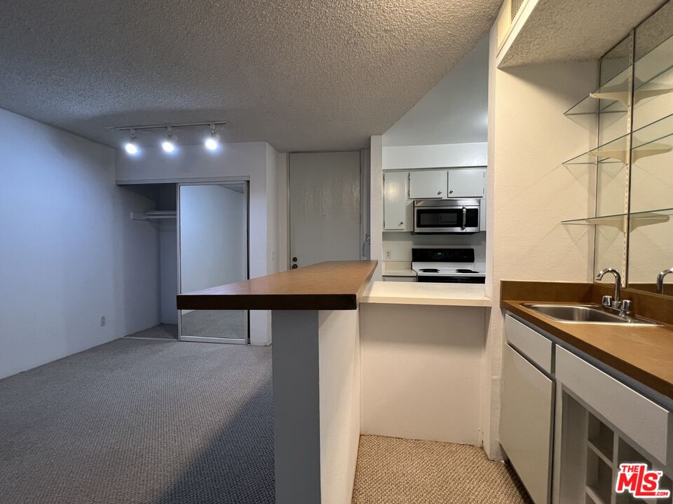 1115 Raintree Circle Culver City, CA 90230 - Photo 17 of 32 a kitchen with stainless steel appliances a stove a sink and a refrigerator