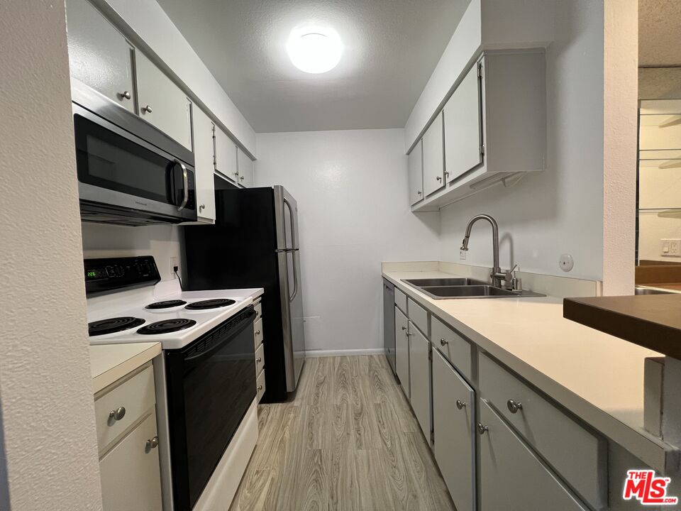 1115 Raintree Circle Culver City, CA 90230 - Photo 31 of 32 a kitchen with stainless steel appliances a sink stove and refrigerator