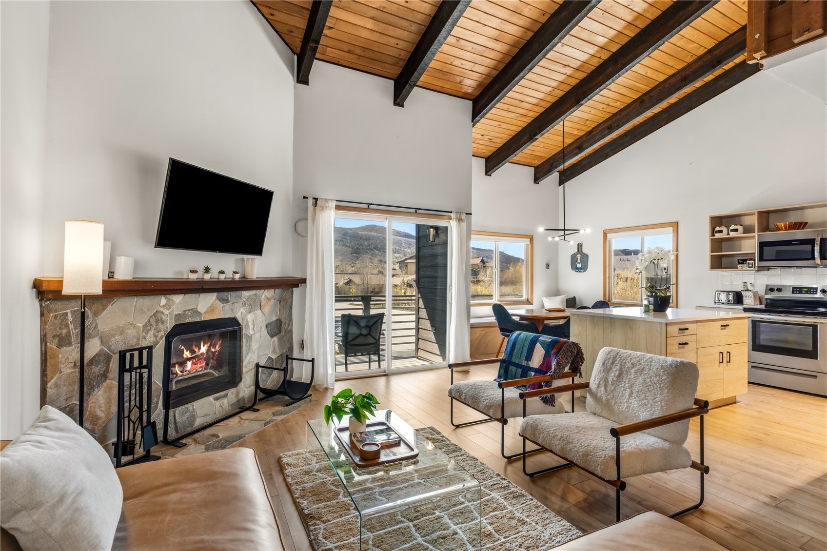1375 Walton Creek Road, Unit 14 Steamboat Springs, CO 80487 - Photo 5 of 38 a living room with furniture a fireplace and a flat screen tv