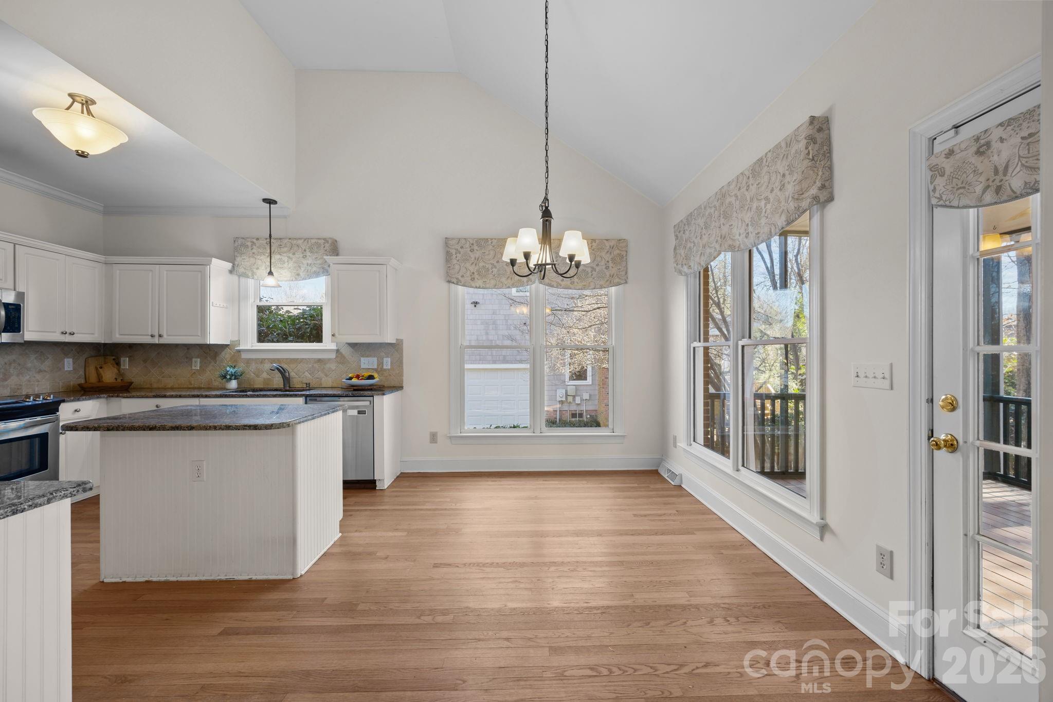100 Martin Street Davidson, NC 28036 - Photo 24 of 47 a large kitchen with granite countertop a stove a sink dishwasher and a large refrigerator with wooden floor