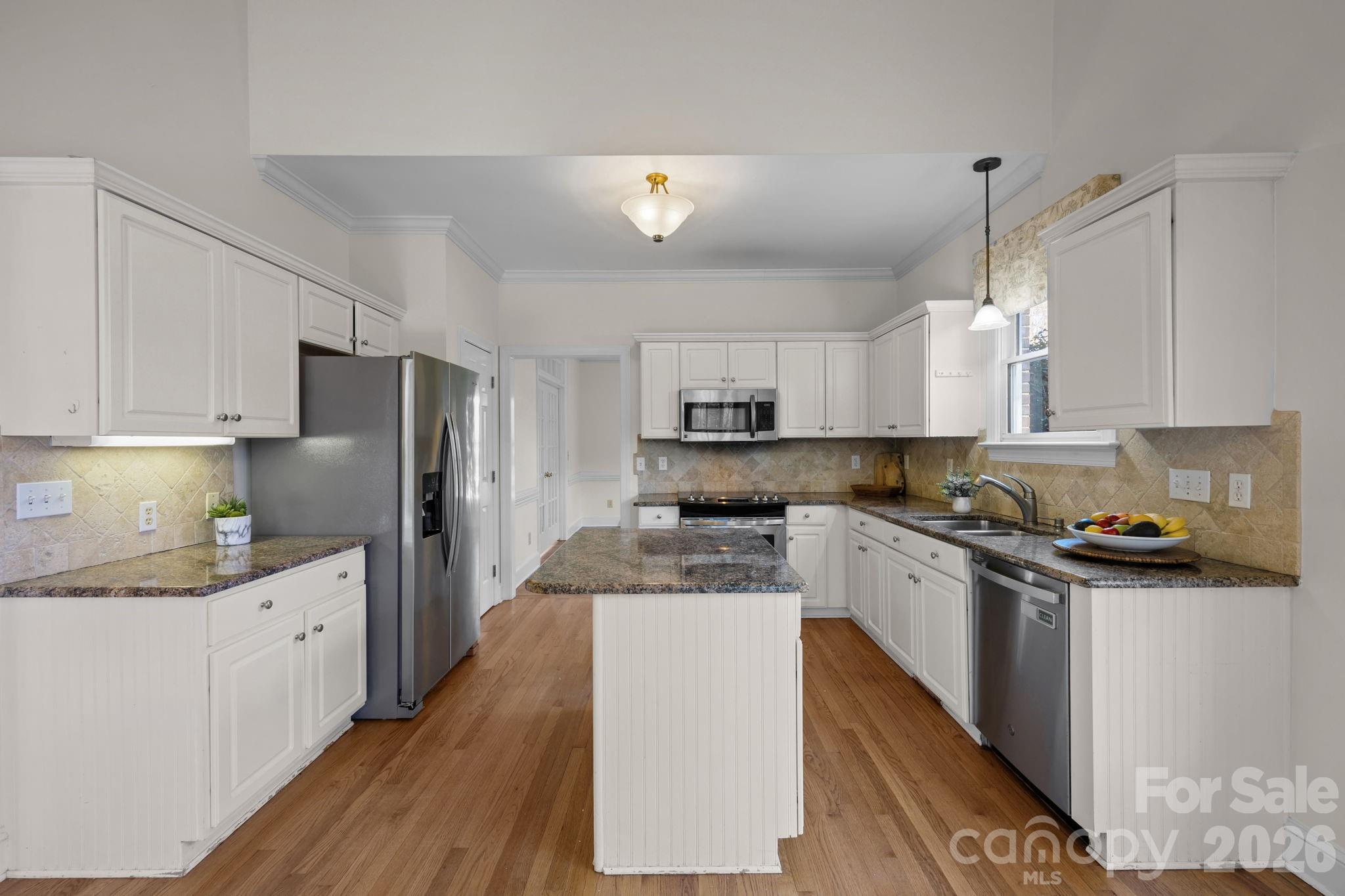 100 Martin Street Davidson, NC 28036 - Photo 26 of 47 a kitchen with stainless steel appliances granite countertop a refrigerator a sink dishwasher a s stove top oven a large island with white cabinets and wooden floor