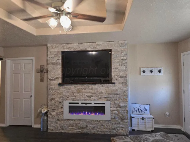 a living room with a fireplace and a flat screen tv