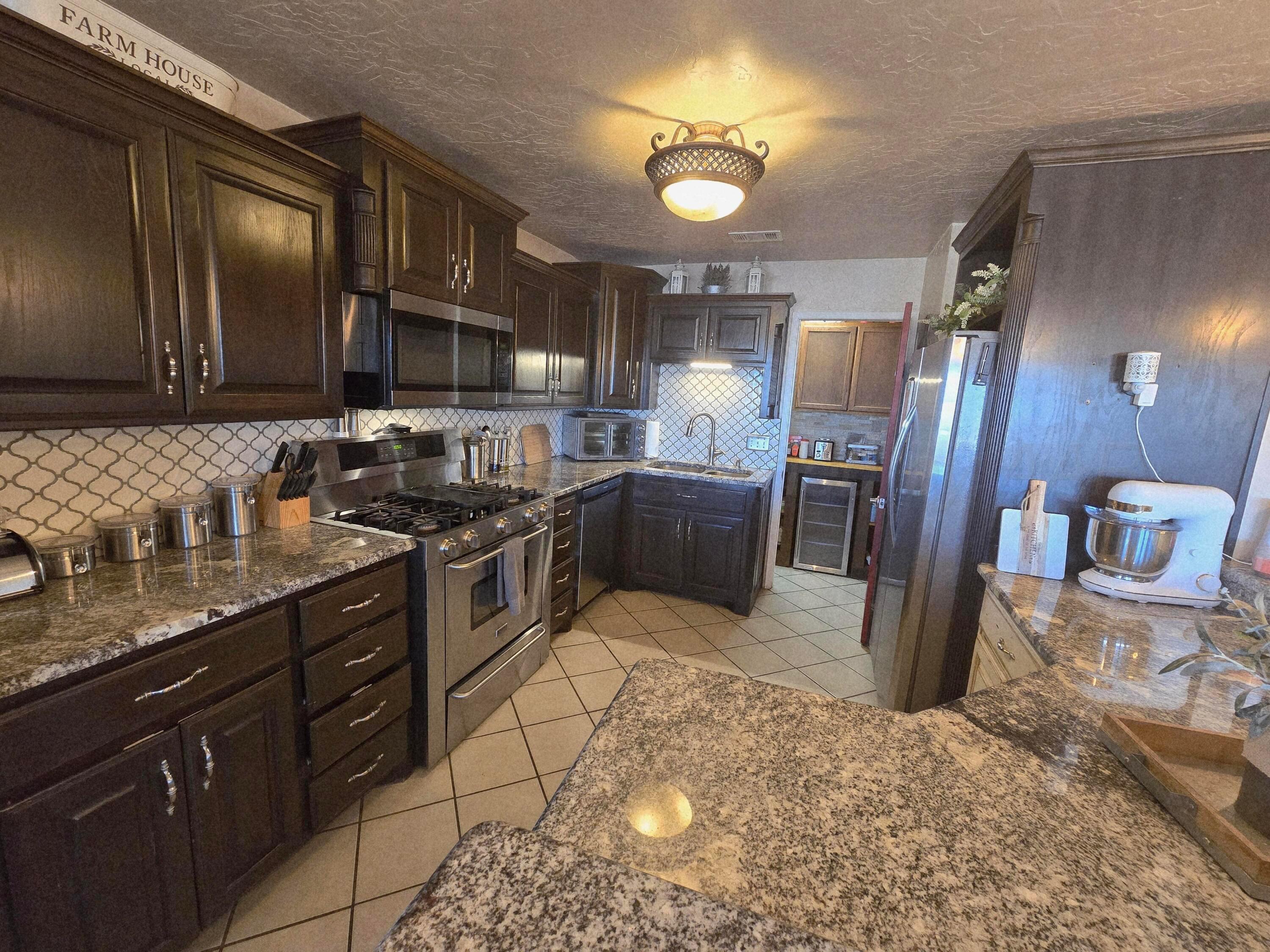 1121 Elmore Street Borger, TX 79007 - Photo 18 of 39 a kitchen with stainless steel appliances granite countertop a sink stove and refrigerator