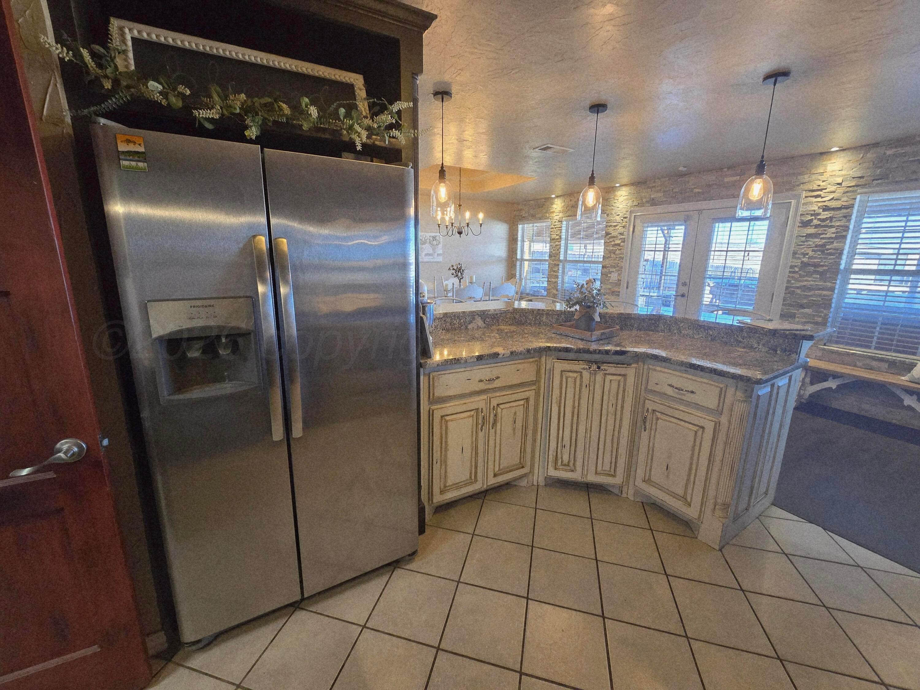 1121 Elmore Street Borger, TX 79007 - Photo 20 of 39 a kitchen with a sink a refrigerator and cabinets