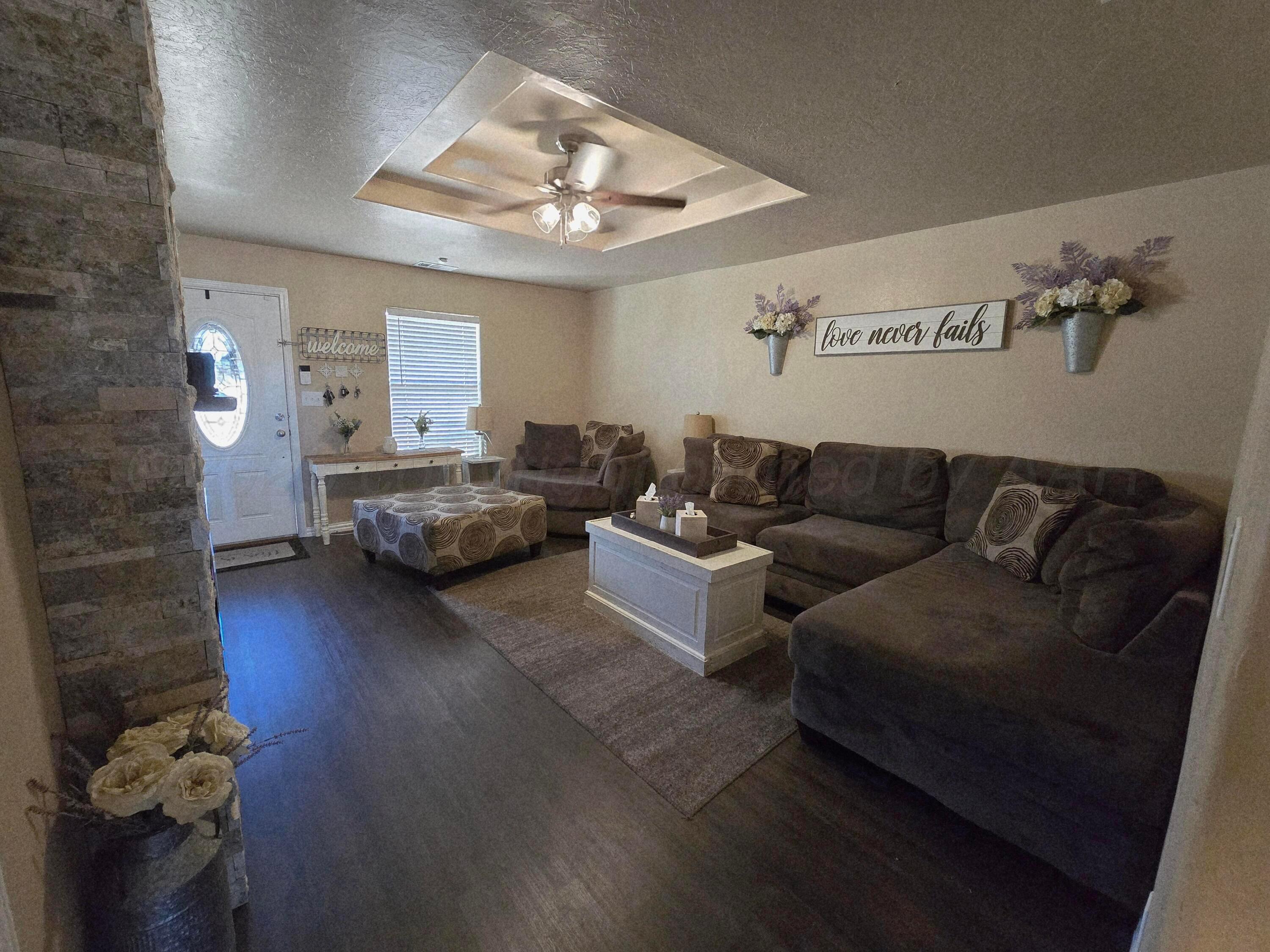 1121 Elmore Street Borger, TX 79007 - Photo 9 of 39 a living room with furniture and a chandelier
