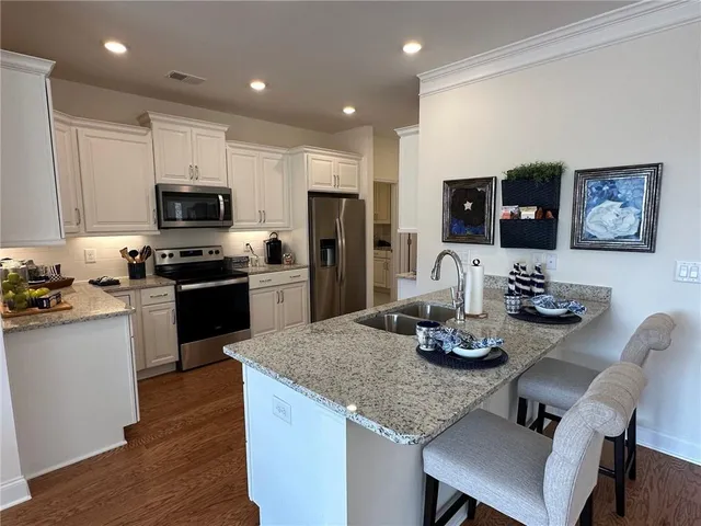 a kitchen with stainless steel appliances granite countertop a stove refrigerator and cabinets