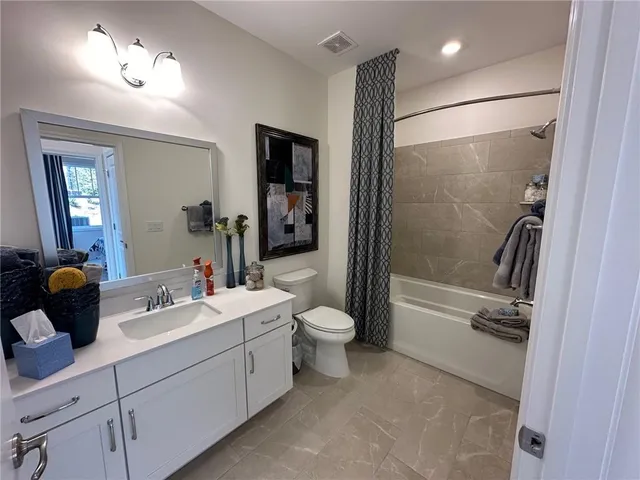 a bathroom with a double vanity sink toilet and shower