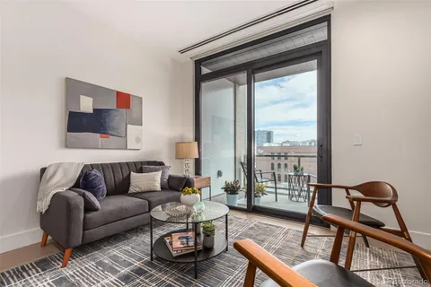 a living room with furniture and a floor to ceiling window