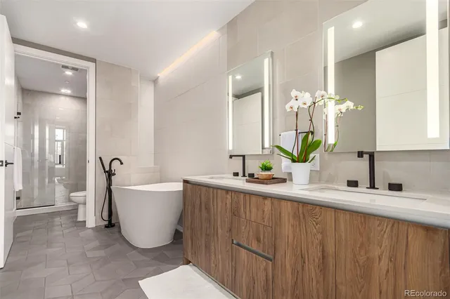 a spacious bathroom with a double vanity sink a mirror and a bathtub