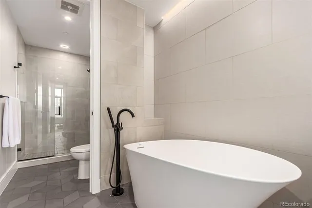a bathroom with a white tub shower and toilet