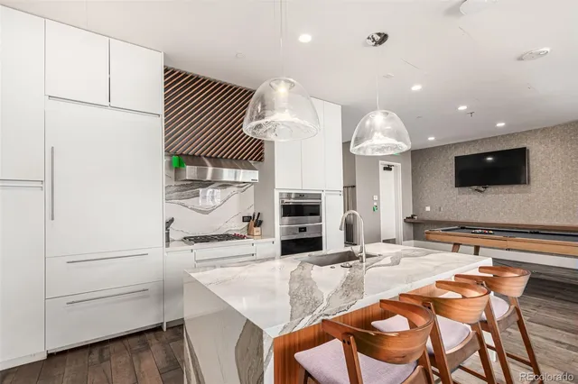 a kitchen with kitchen island granite countertop a sink and a refrigerator