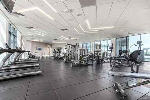 a gym room with lots of furniture and a chandelier