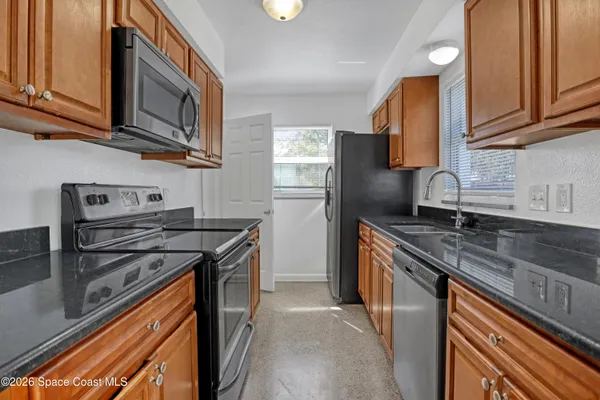 a kitchen with stainless steel appliances granite countertop a sink stove microwave refrigerator and cabinets