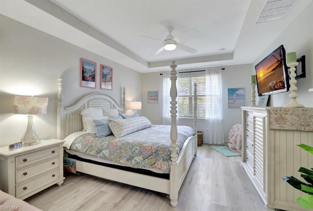 20183 Torch Key Way Estero, FL 33928 - Photo 8 of 30 Bedroom featuring a raised ceiling, wood-style flooring, and a ceiling fan